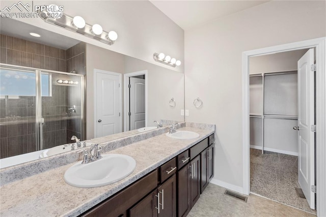 bathroom with tile patterned flooring, vanity, and an enclosed shower