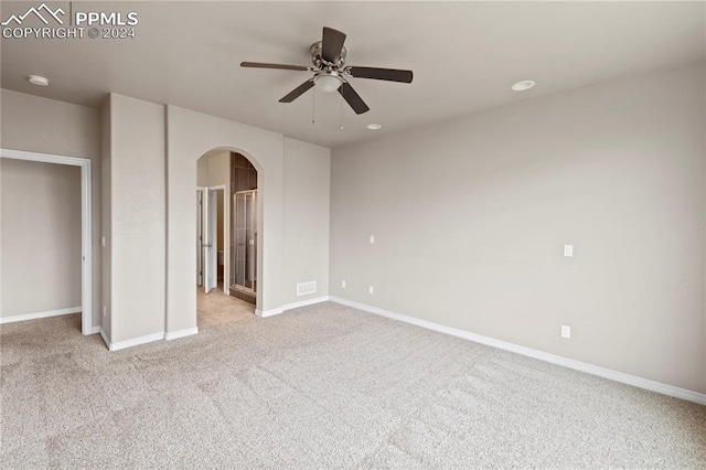 empty room with ceiling fan and light carpet