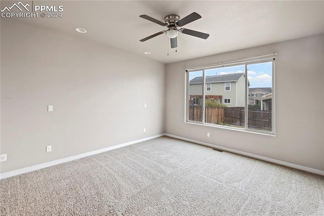 carpeted spare room featuring ceiling fan