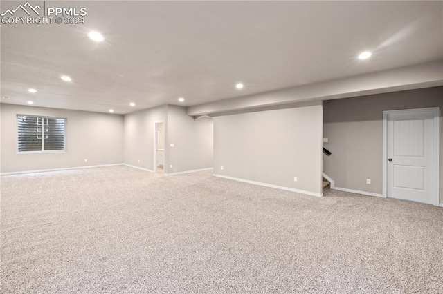 basement featuring light carpet