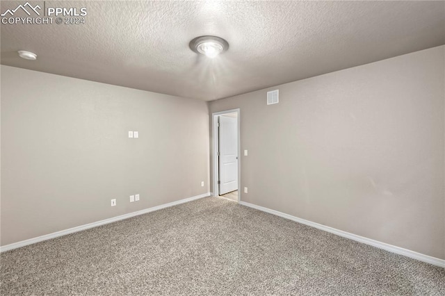 empty room featuring a textured ceiling and carpet flooring