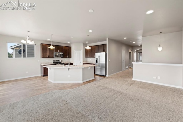 kitchen featuring pendant lighting, stainless steel appliances, dark brown cabinets, and light wood-type flooring