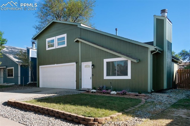 view of front of home with a garage and a front lawn