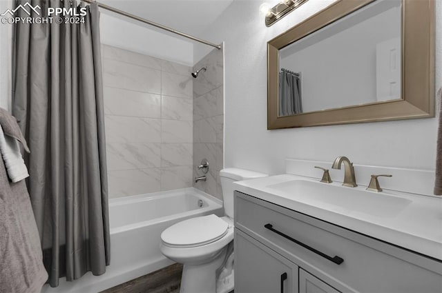 full bathroom with shower / bath combination with curtain, hardwood / wood-style floors, vanity, and toilet