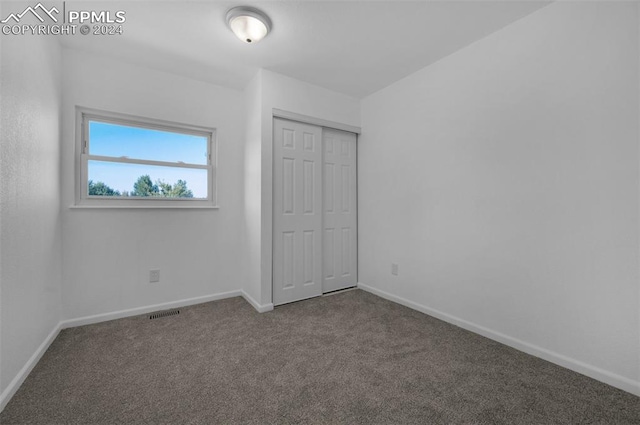 unfurnished bedroom featuring carpet flooring and a closet