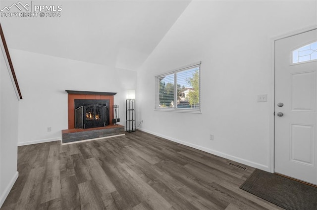 unfurnished living room with dark wood-type flooring and high vaulted ceiling