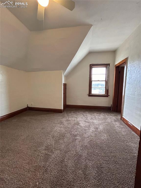 additional living space featuring vaulted ceiling, ceiling fan, and carpet flooring