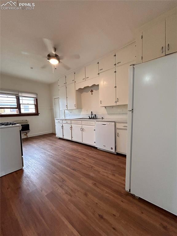 kitchen featuring ceiling fan, sink, white appliances, white cabinetry, and dark hardwood / wood-style flooring