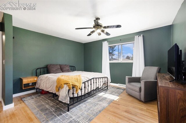 bedroom with light hardwood / wood-style flooring and ceiling fan