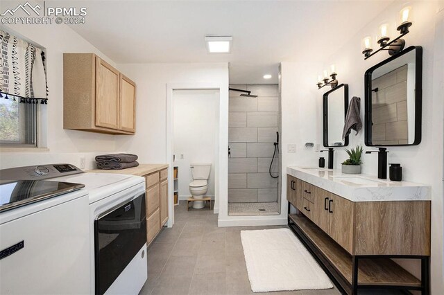 interior space with light tile patterned flooring, sink, washer and dryer, and light brown cabinets