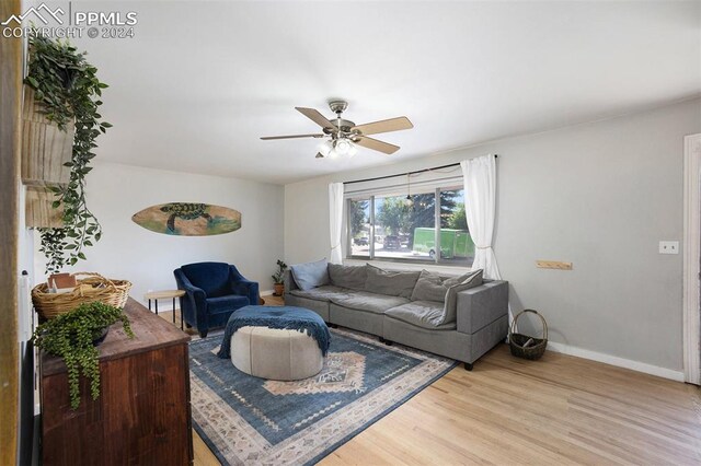 living room featuring light hardwood / wood-style flooring and ceiling fan