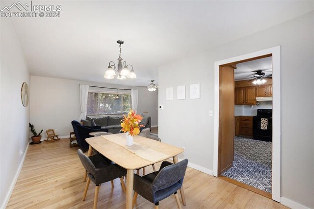 dining area featuring ceiling fan with notable chandelier and light hardwood / wood-style flooring