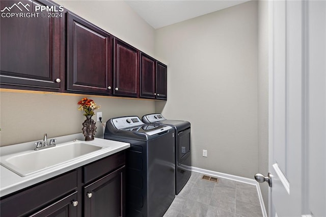 laundry room featuring cabinets, washing machine and clothes dryer, and sink