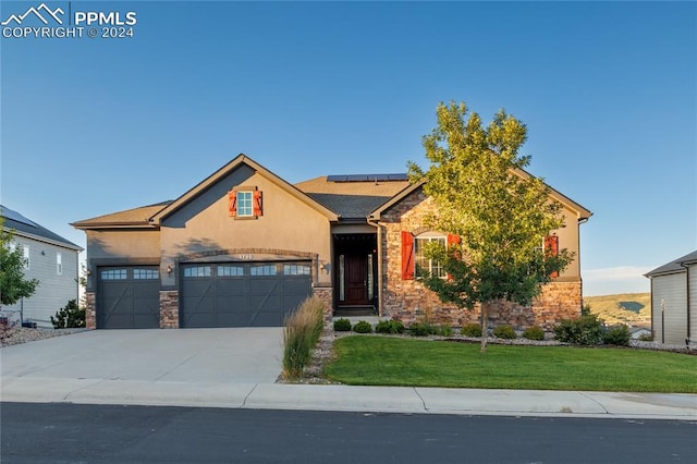 craftsman house featuring a front yard and a garage