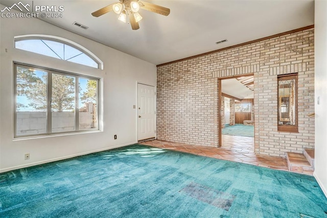 unfurnished room featuring ceiling fan, brick wall, and carpet floors