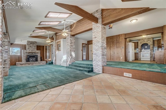 interior space with a fireplace, ceiling fan, and a skylight