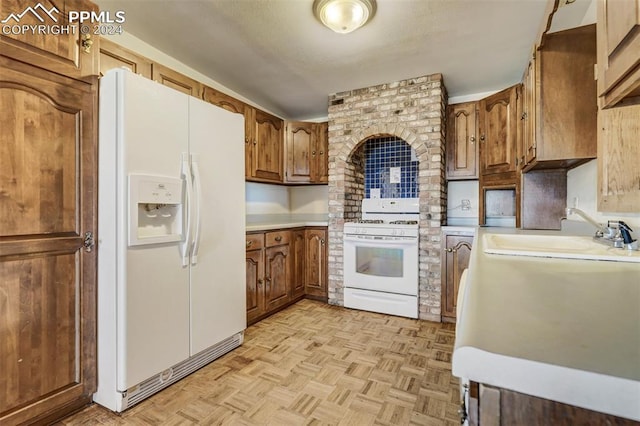 kitchen featuring sink, white appliances, and light parquet floors