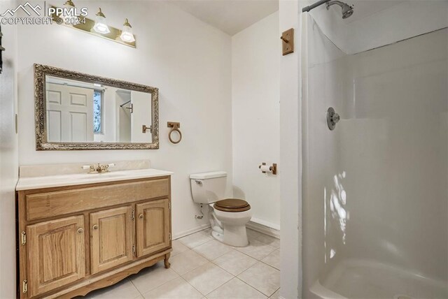 bathroom featuring tile patterned floors, a shower, vanity, and toilet