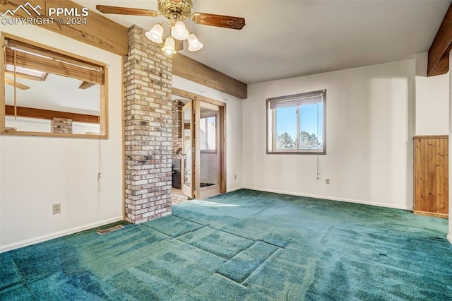 unfurnished living room with carpet flooring, beam ceiling, and ceiling fan