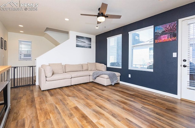 living room featuring hardwood / wood-style floors and ceiling fan