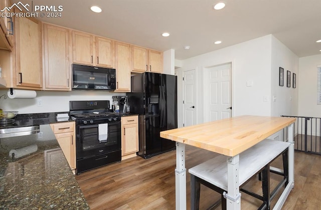 kitchen featuring black appliances, dark stone countertops, light brown cabinetry, and dark wood-type flooring