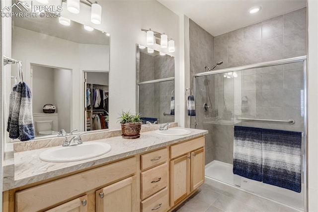 bathroom with walk in shower, tile patterned floors, vanity, and toilet