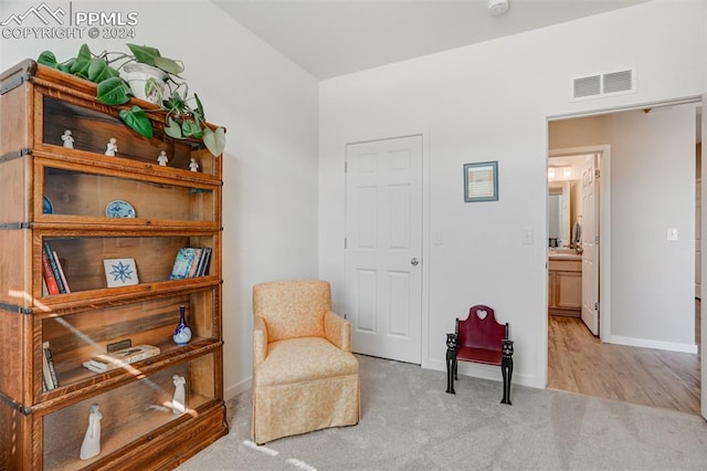 living area featuring light carpet