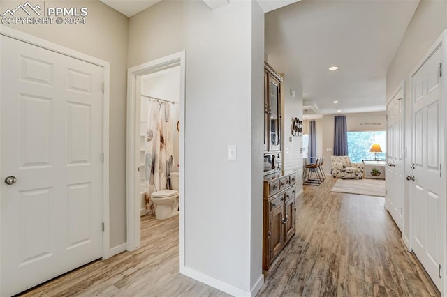 corridor with light hardwood / wood-style floors