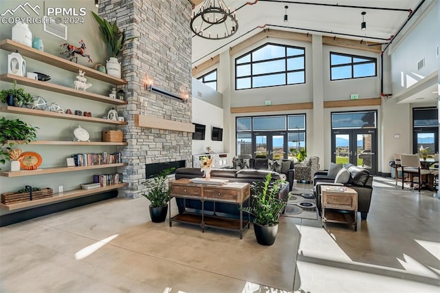 interior space featuring french doors, a notable chandelier, a fireplace, and high vaulted ceiling