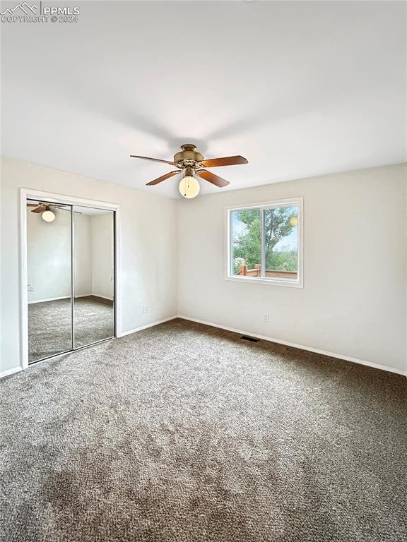 unfurnished bedroom with ceiling fan, carpet floors, and a closet