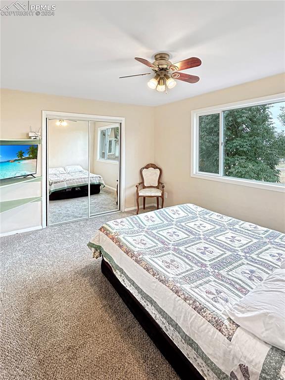 carpeted bedroom featuring a closet and ceiling fan