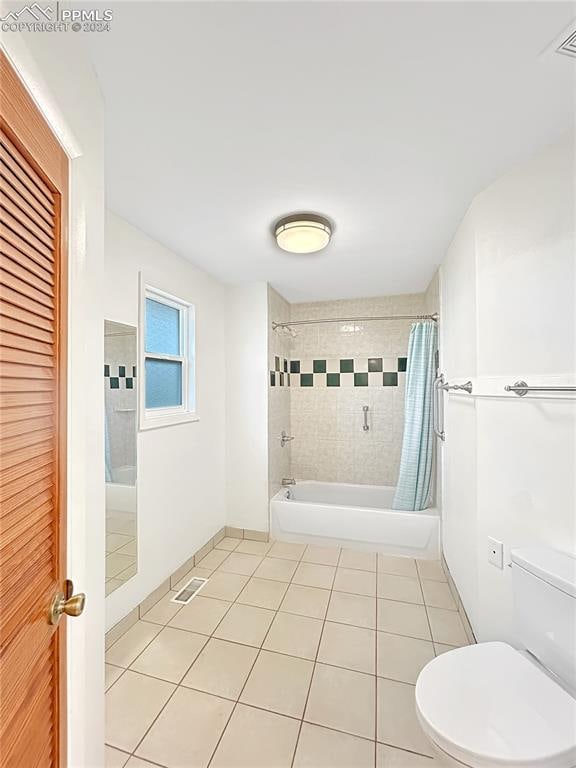 bathroom with shower / tub combo with curtain, toilet, and tile patterned floors