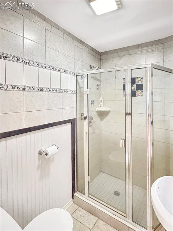 bathroom with walk in shower, toilet, and tile patterned floors