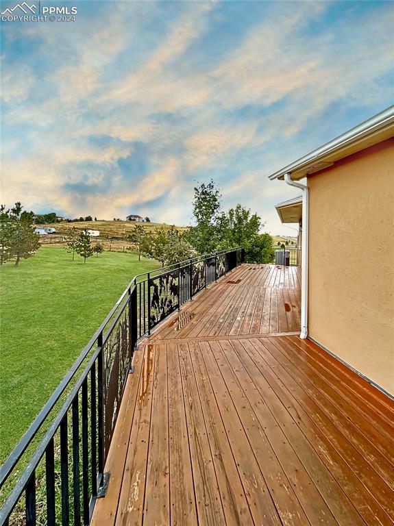 wooden deck featuring a lawn