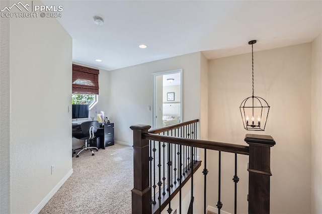 hallway featuring an inviting chandelier and carpet flooring