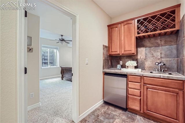 kitchen with ceiling fan, stainless steel dishwasher, tasteful backsplash, sink, and tile countertops