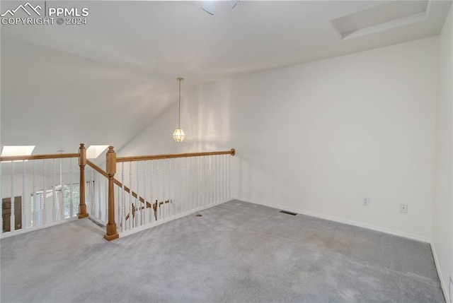 spare room featuring carpet flooring and lofted ceiling with skylight