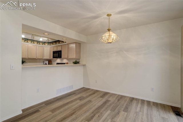 kitchen with wood-type flooring, light brown cabinets, an inviting chandelier, and hanging light fixtures