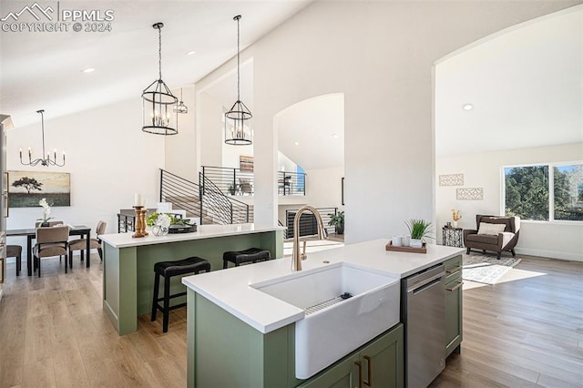 kitchen with a kitchen island with sink, light hardwood / wood-style flooring, high vaulted ceiling, dishwasher, and green cabinets