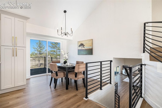 dining space featuring an inviting chandelier, light hardwood / wood-style flooring, and high vaulted ceiling