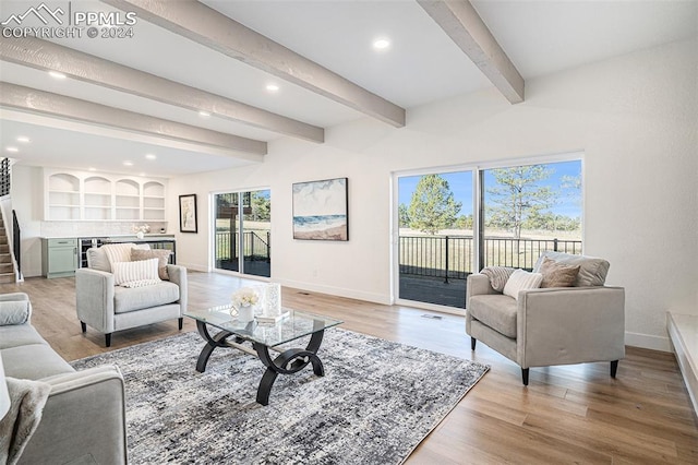 living room featuring light wood-type flooring, built in features, and beam ceiling