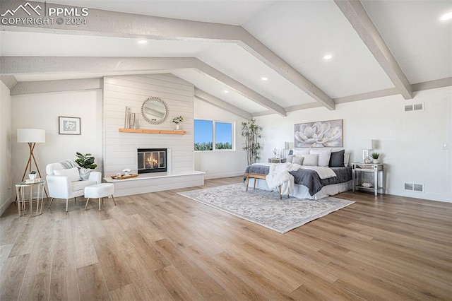 bedroom with wood-type flooring and vaulted ceiling with beams