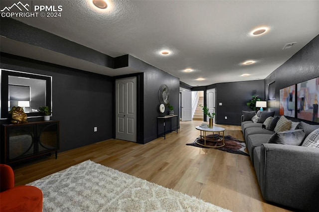 living room featuring light hardwood / wood-style flooring and a textured ceiling