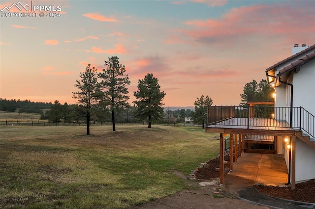 yard at dusk with a rural view and a wooden deck