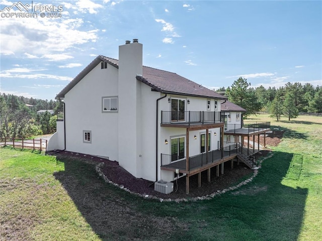 back of property with central AC unit and a lawn