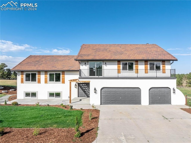 mediterranean / spanish-style home with a balcony, a garage, and a front lawn