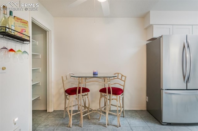 kitchen featuring stainless steel refrigerator, light tile patterned floors, and ceiling fan