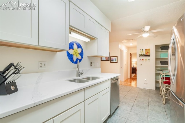 kitchen with white cabinets, ceiling fan, appliances with stainless steel finishes, and sink