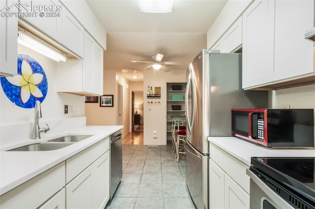 kitchen featuring light tile patterned flooring, sink, white cabinetry, appliances with stainless steel finishes, and ceiling fan