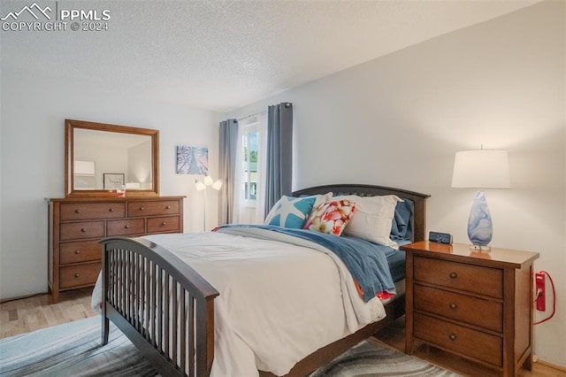 bedroom with a textured ceiling and hardwood / wood-style floors